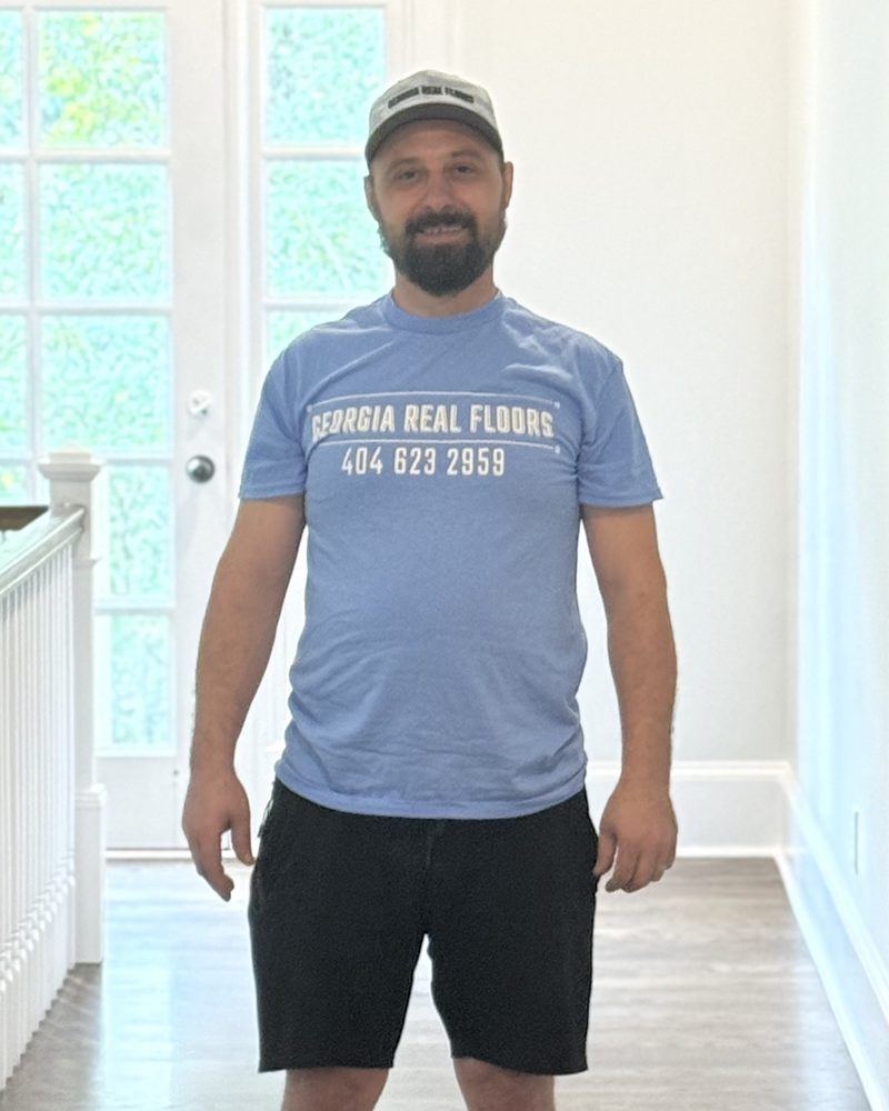 Christian Rus, owner of Georgia Real Floors, on a finished hardwood floor in an Atlanta home